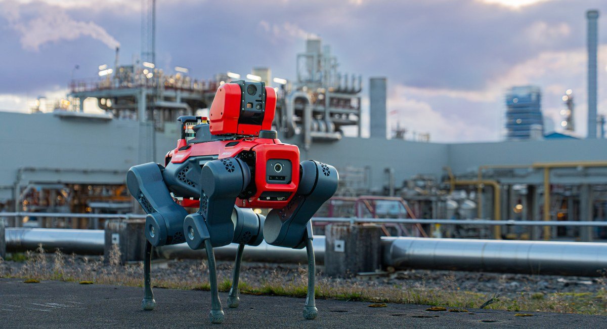 ANYmal X walking through an industrial plant at dusk
