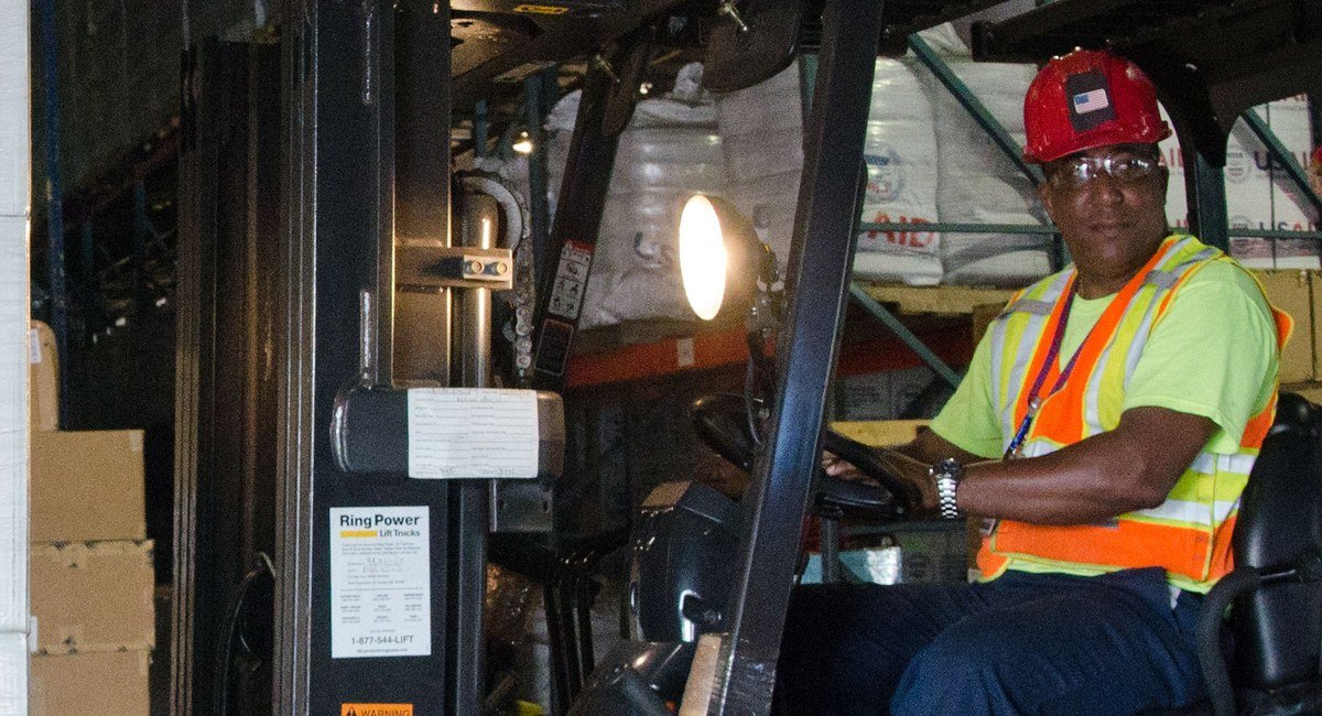 A forklift operator moves goods inside a warehouse