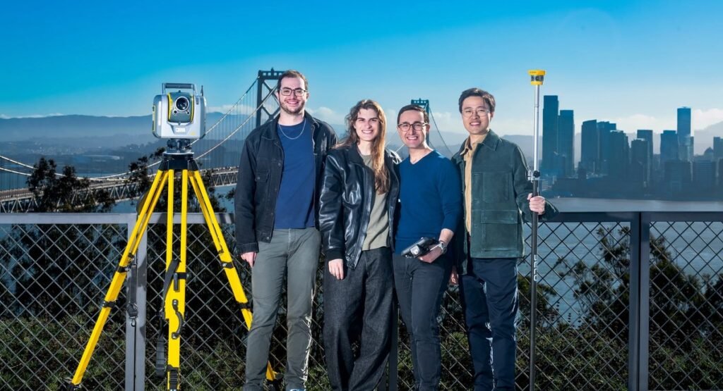 Mach9 team standing with a laser scanner and survey pole in front of the San Francisco Bay Bridge